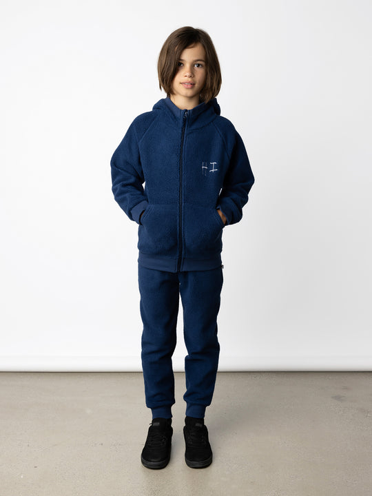 Minti kids clothing. Super cosy and soft Zip Up made in teddy with 2x2 rib cuffs and hem. Front pocket to keep hands warm. 70% Polyester // 30% Cotton.