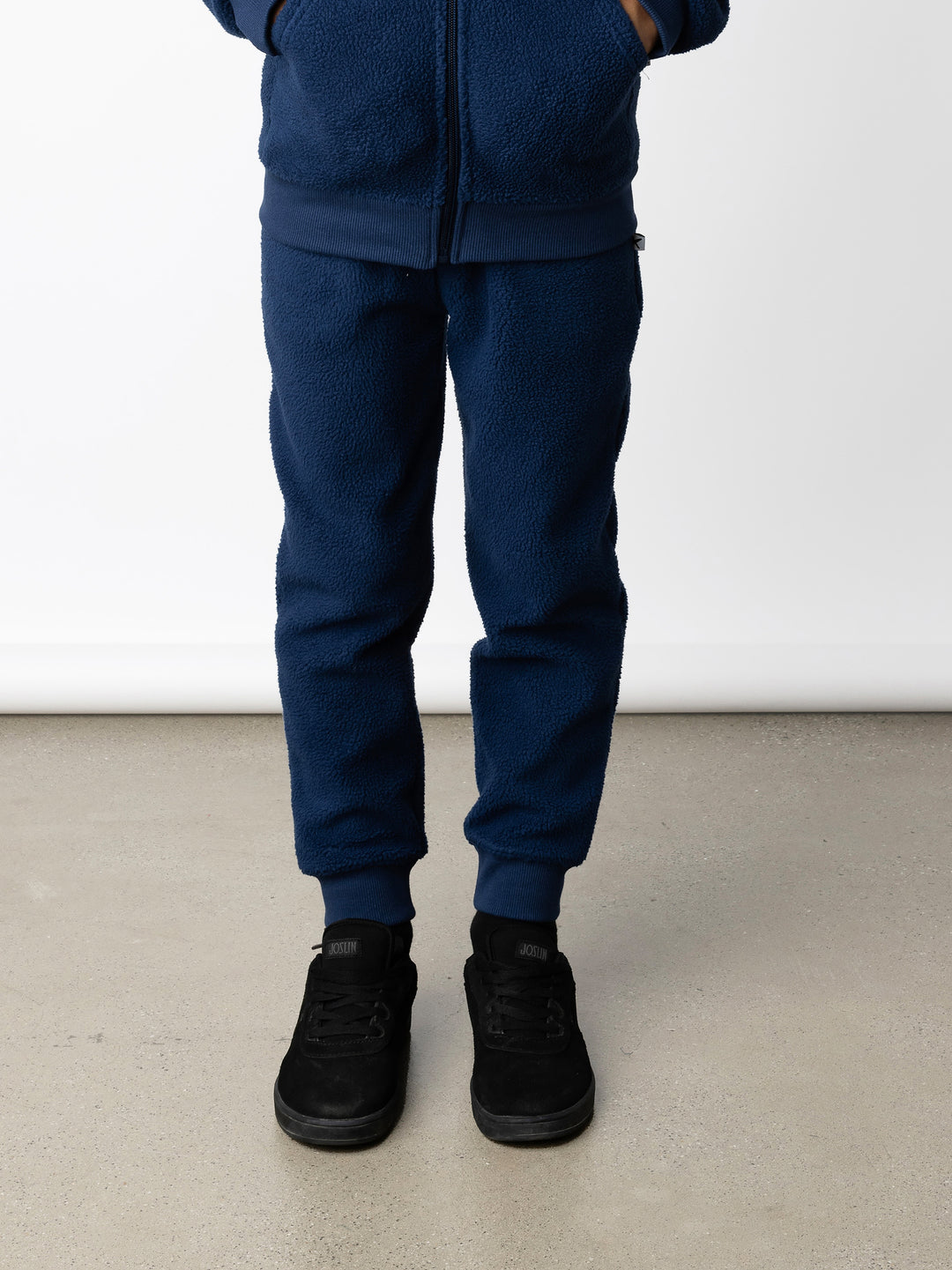 Minti kids clothing. Super cosy and soft loose leg trackies made in teddy with 2x2 rib cuffs. Front pocket to keep hands warm. Small Minti embroidery on the back. 70% Polyester // 30% Cotton.