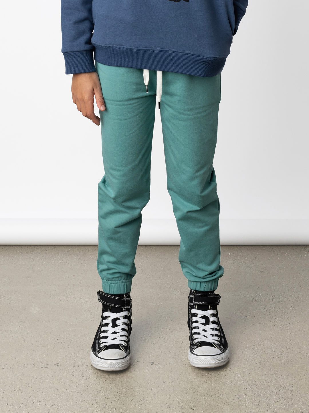 Minti kids clothing. Wider leg trackies with front pockets, shoelace cord, 2x2 rib elasticated waistband and gathered cuffs. Small Minti embroidery on the back. 320 Gram // 95% Cotton // 5% Elastane.