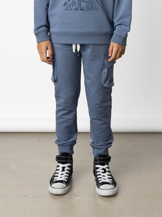 Minti kids clothing. Tapered leg trackies with awesome cargo style pockets, front pockets, shoelace cord and 2x2 rib waistband and cuffs. 320 Gram // 95% Cotton // 5% Elastane.