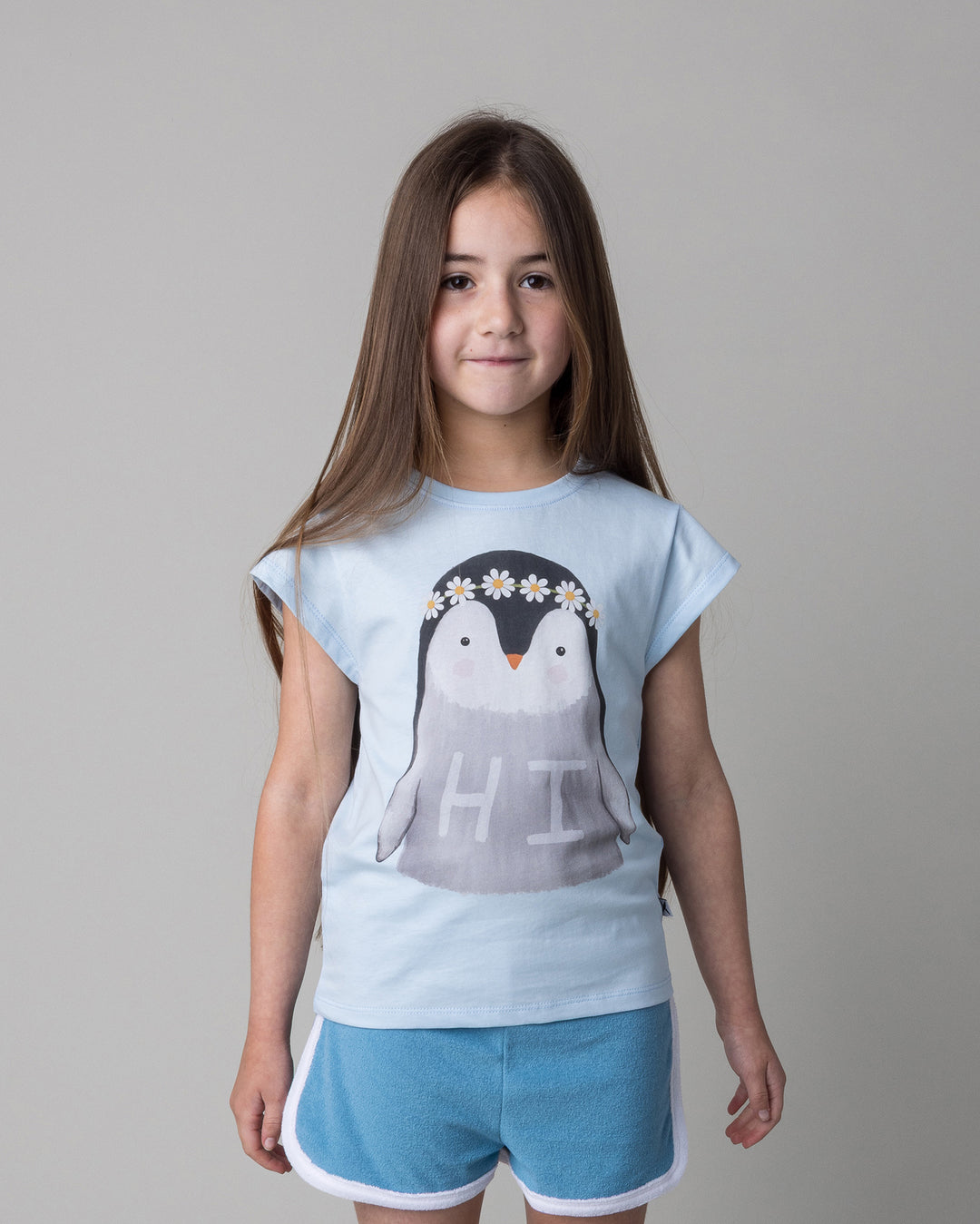 Close up of the Flower Penguin Tee in light blue on a kid, front view