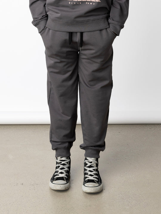 Minti kids clothing. Relaxed universal fit trackies with cosy side pockets, elasticated waistband, shoelace cord and 2x2 Rib cuffs. Small Minti embroidery on the back. 320 Gram // 95% Cotton // 5% Elastane.