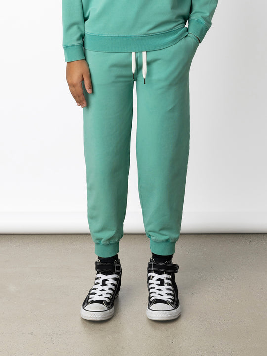 Minti kids clothing. Relaxed universal fit trackies with cosy side pockets, elasticated waistband, shoelace cord and 2x2 Rib cuffs. Small Minti embroidery on the back. 260 Gram // 95% Cotton // 5% Elastane.