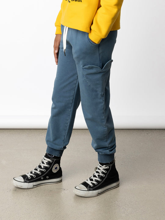Minti kids clothing. Relaxed fit trackies with a super cool heart shaped side pocket. Front pockets, elasticated waistband, shoelace cord and 2x2 Rib cuffs. 260 Gram // 95% Cotton // 5% Elastane.
