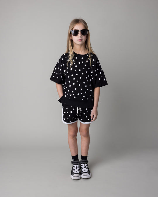 Kid wearing the Spotty Short Sleeve Crew in black with the Spotty Short in black and white, front view