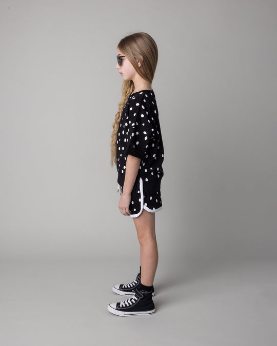 Kid wearing the Spotty Short Sleeve Crew in black with the Spotty Short in black and white, side view