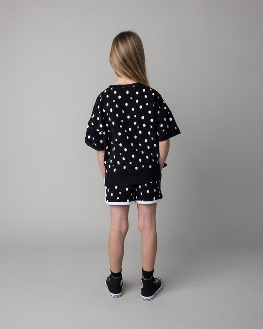 Kid wearing the Spotty Short Sleeve Crew in black with the Spotty Short in black and white, back view