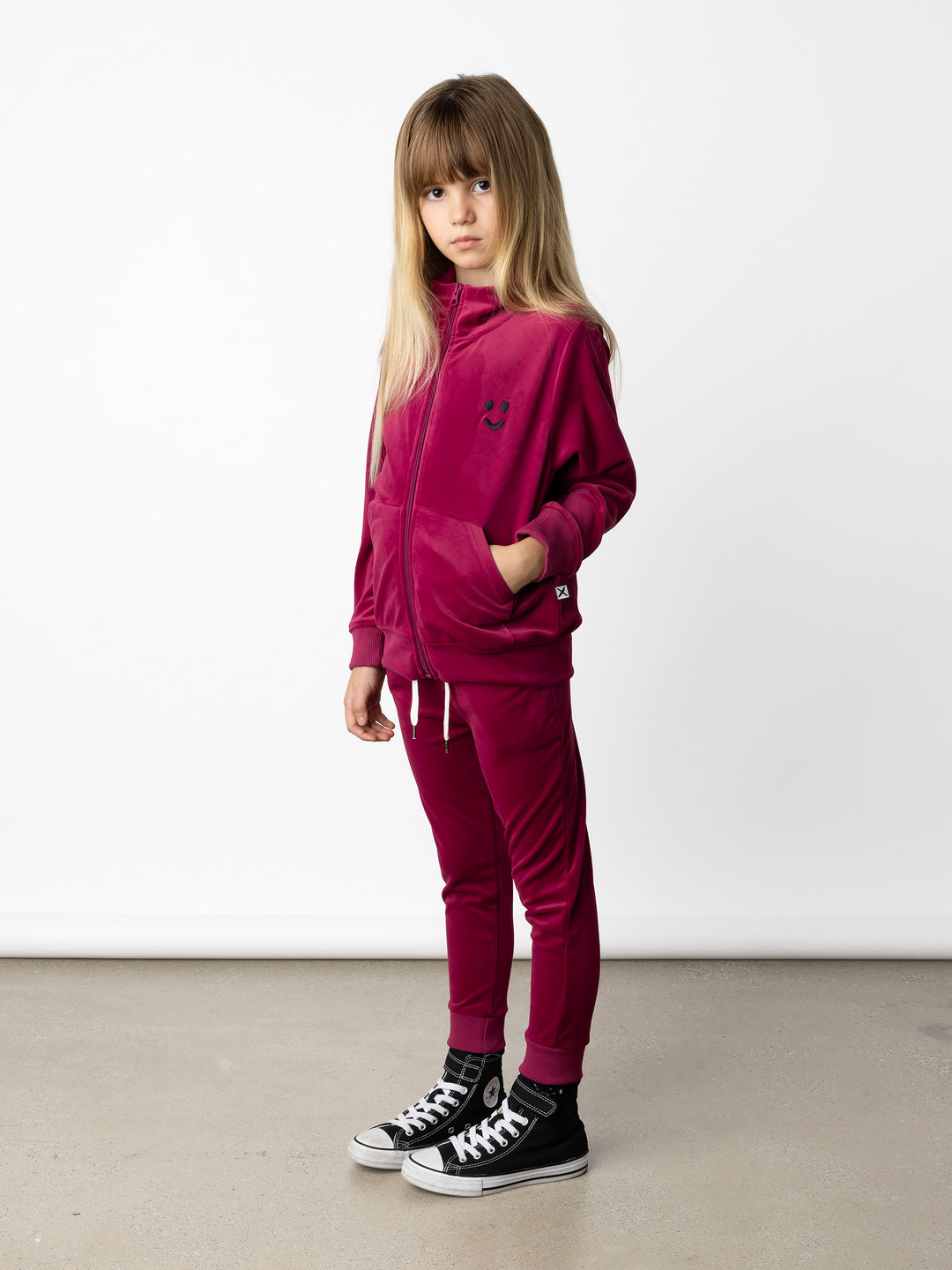 Minti kids clothing. Super cosy and soft zip up high neck crew, made in super soft velvet. Front kangaroo pocket to keep hands warm. Small Happy Face embroidery on the front. 92% Polyester // 8% Spandex.