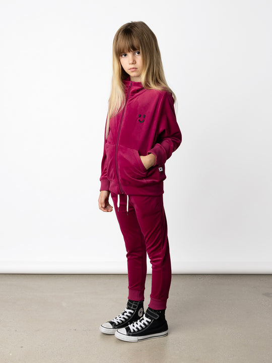 Minti kids clothing. Super cosy and soft zip up high neck crew, made in super soft velvet. Front kangaroo pocket to keep hands warm. Small Happy Face embroidery on the front. 92% Polyester // 8% Spandex.