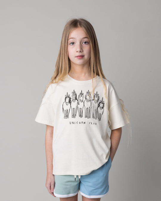 Close up of the Unicorn Club Tee in cream on a kid, front view