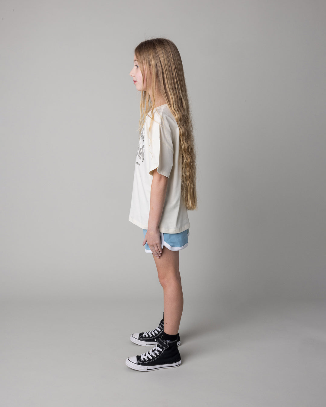 Kid wearing the Unicorn Club Tee in cream with the Sprint Short in mint and aqua and lilac, side view