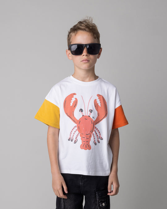 Close up of the Vacay Crayfish Tee in off white and mustard and orange on a kid, front view