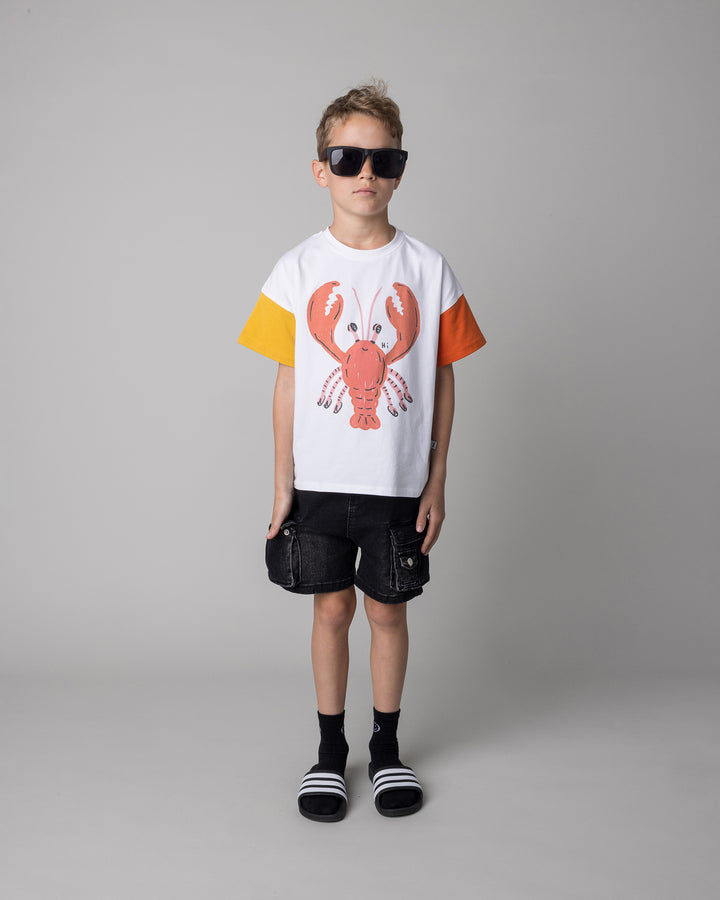 Kid wearing the Vacay Crayfish Tee in off white and mustard and orange, front view