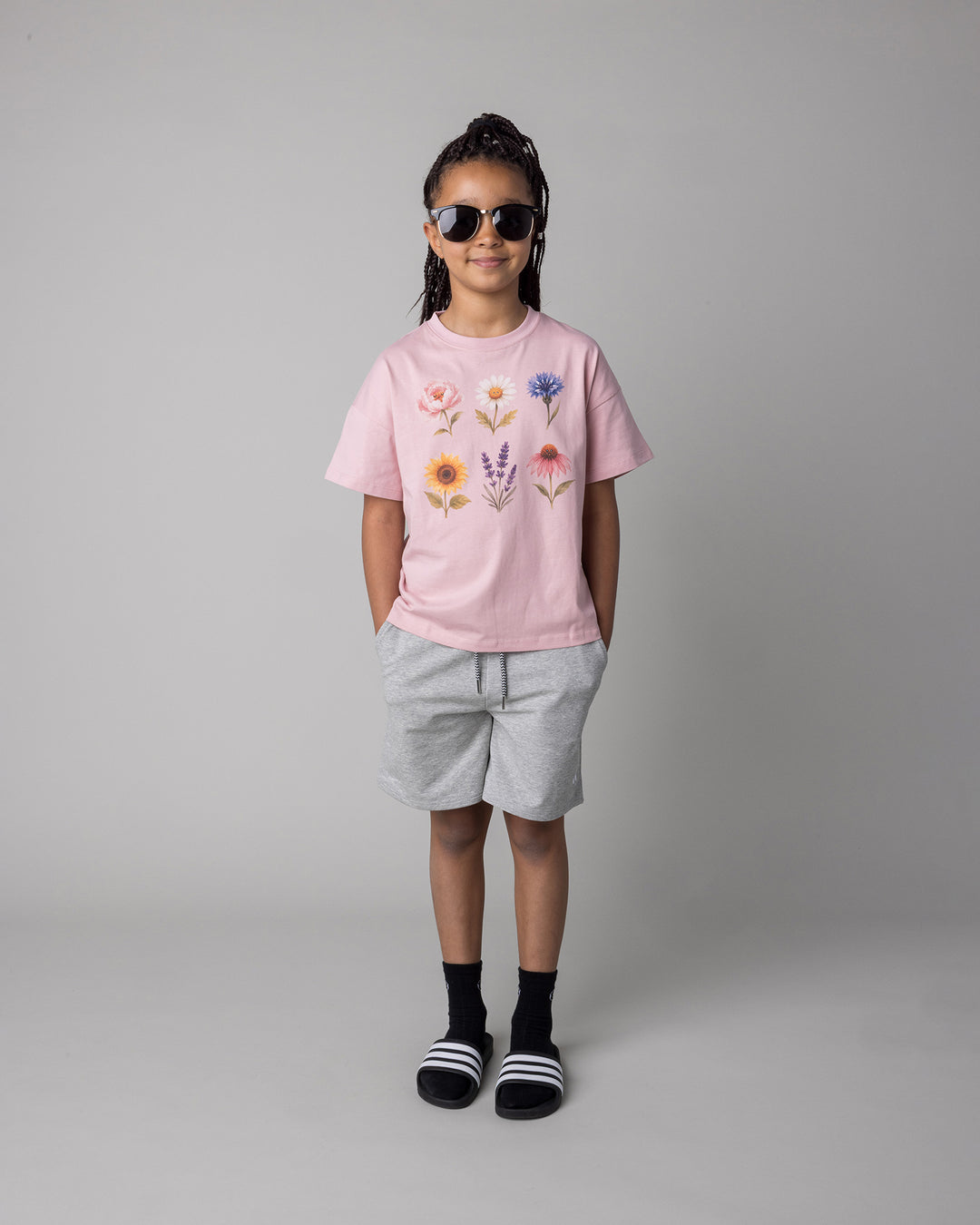 Kid wearing the Smile Short in grey marle with the Flower Friends Tee in muted pink, front view