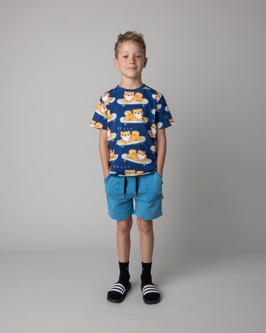 Kid wearing the Skate Puppy Tee in midnight with the Blasted Track Short in sky wash, front view