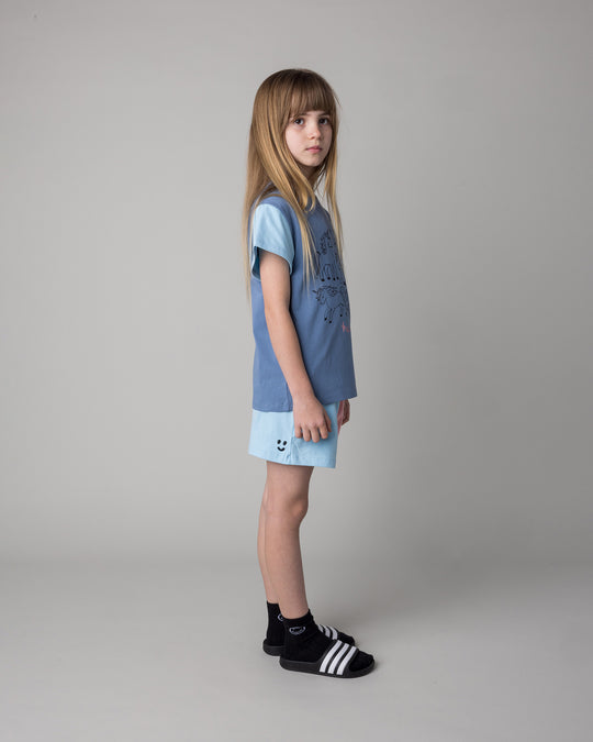 Kid wearing the Hello Unicorns Tee in mid blue and light blue and pink with the Two Tone Short in light blue and pink, side view