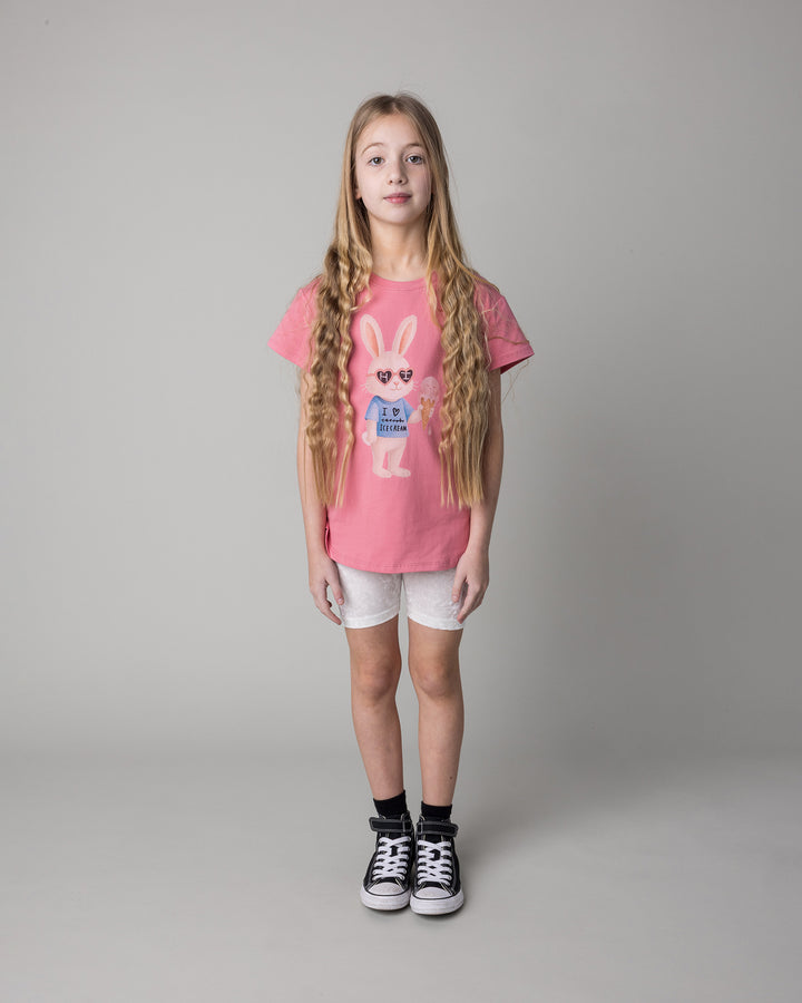 Kid wearing the Icecream Bunny Tee in candy with the Velvet Bike Pant in cream, front view