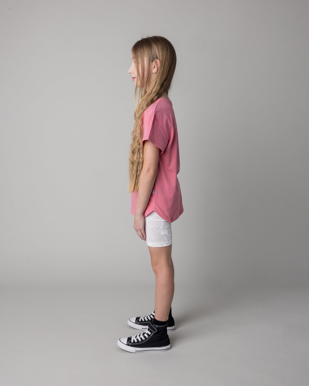 Kid wearing the Icecream Bunny Tee in candy with the Velvet Bike Pant in cream, side view