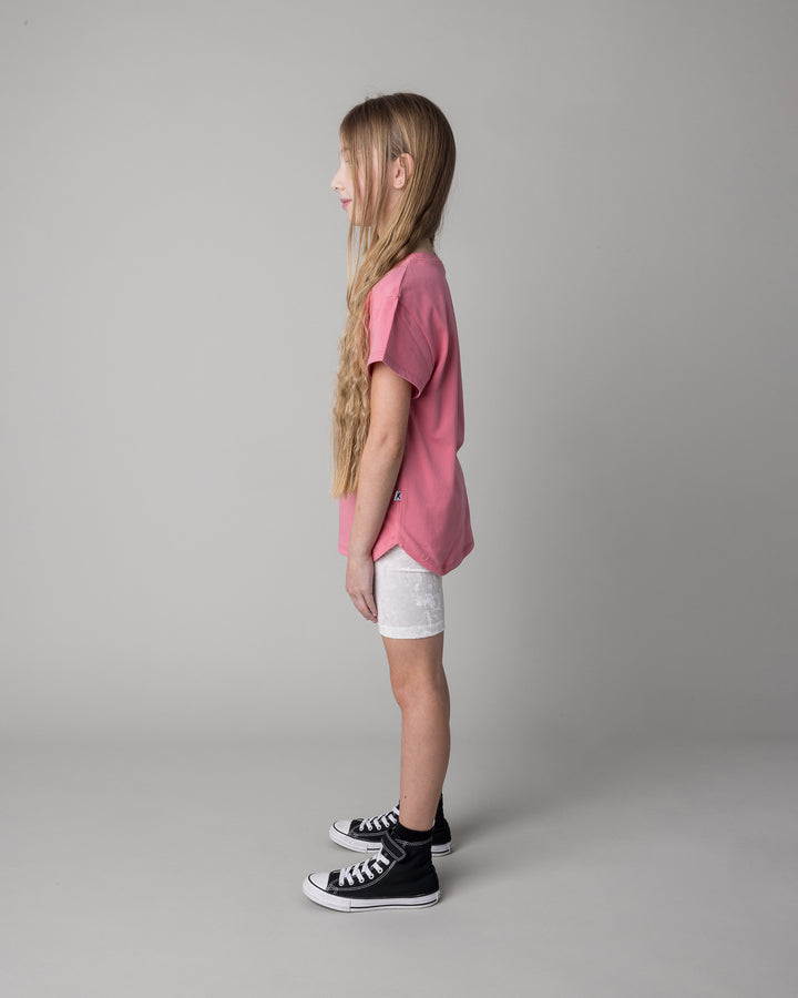 Kid wearing the Icecream Bunny Tee in candy with the Velvet Bike Pant in cream, side view