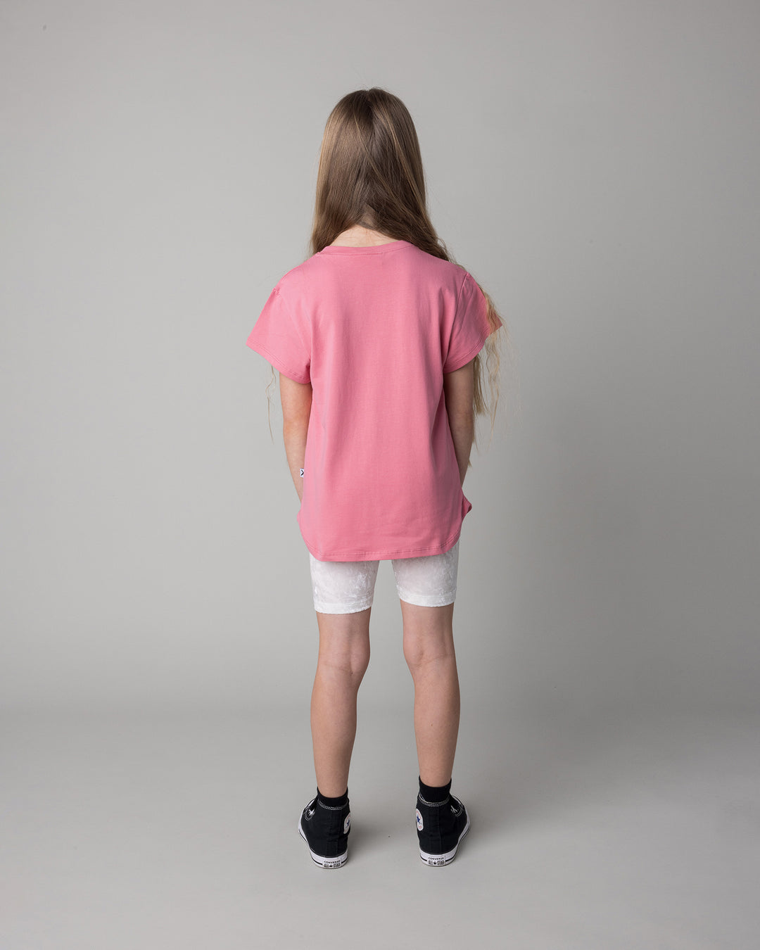 Kid wearing the Icecream Bunny Tee in candy with the Velvet Bike Pant in cream, back view