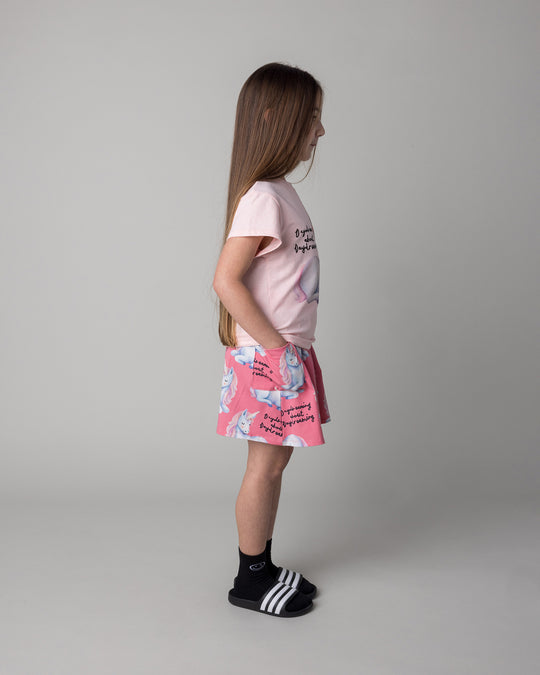 Kid wearing the Daydreaming Unicorn Skirt in candy with the Daydreaming Unicorn Tee in pink marle, side view