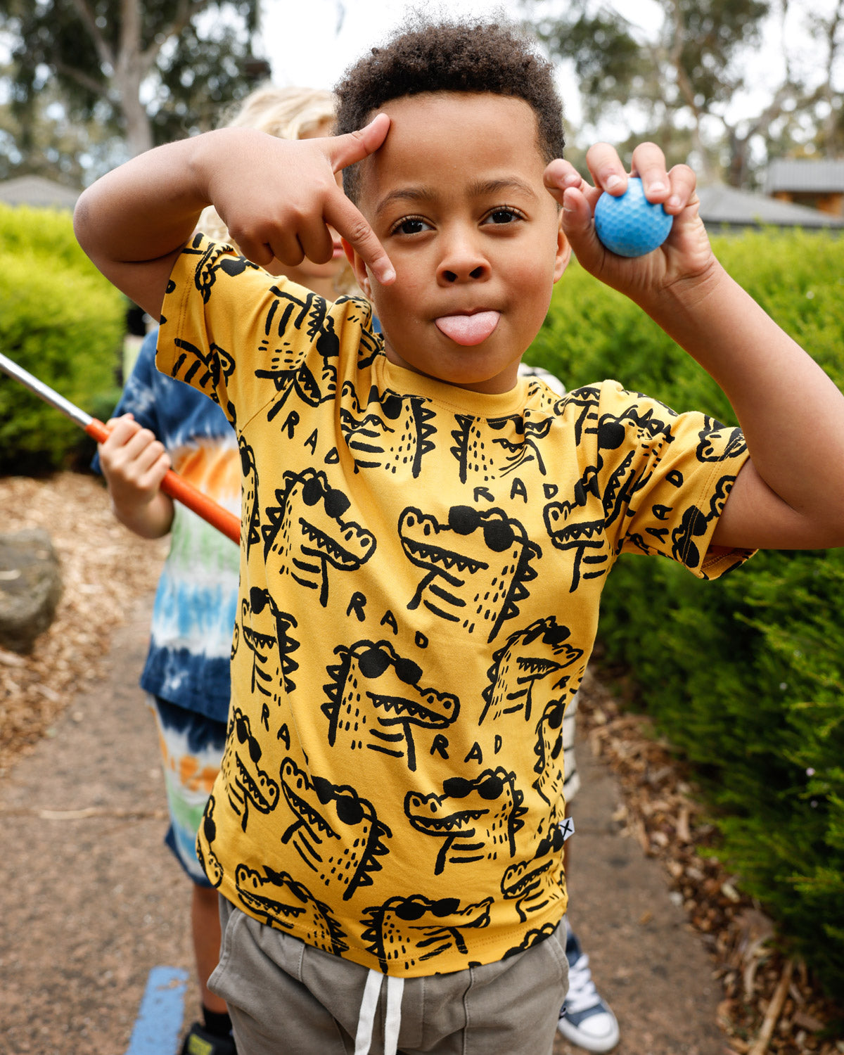 Kid in the Minti Rad Croc tee at mini golf