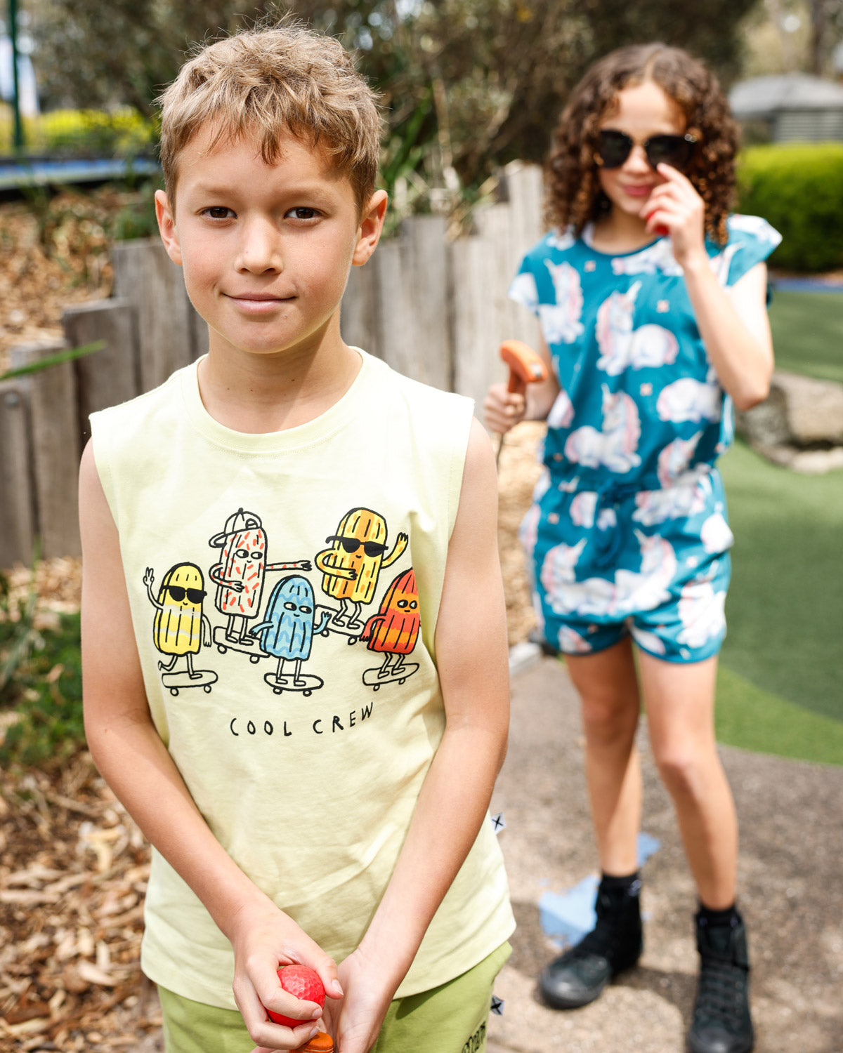 Kid in the Minti Cool Crew sleeveless tee at mini golf