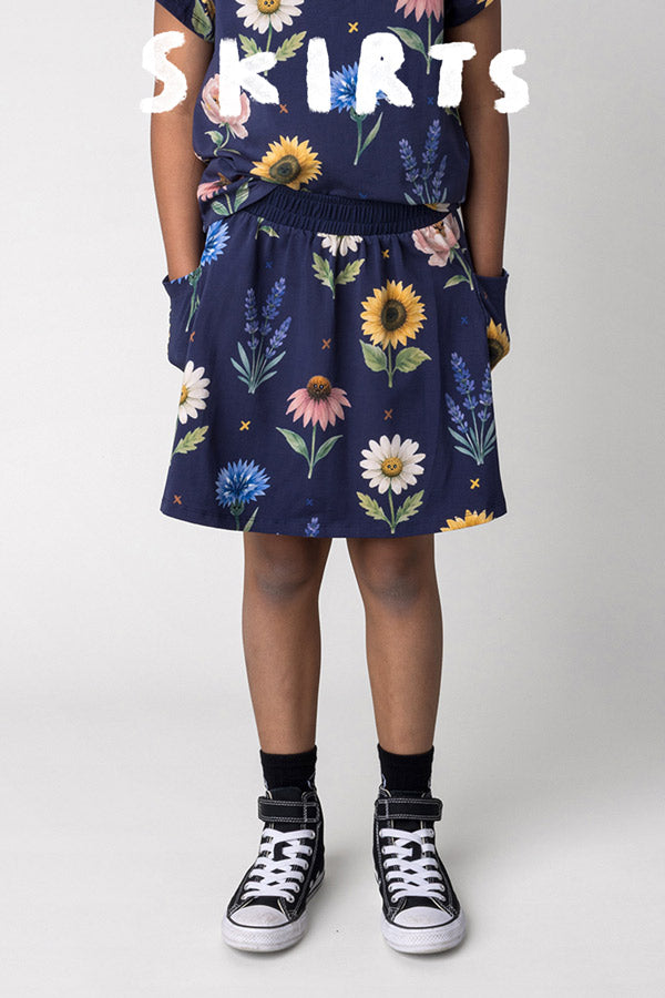 Shop skirts at Minti, kid wearing the Flower Friends Skirt in ink